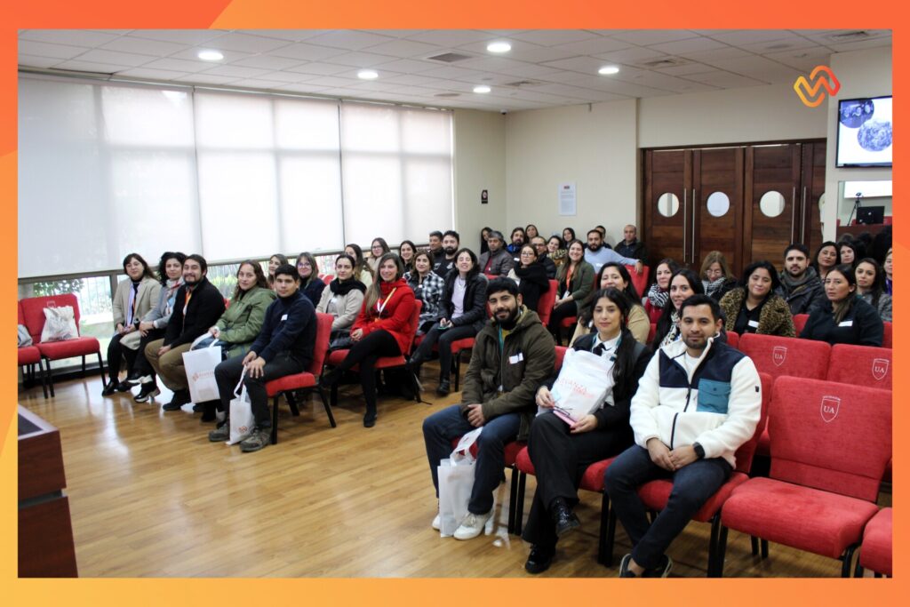 foto panorámica de todas las personas asistentes al encuentro regional de inclusión laboral en talca. Las personas están sentadas sonriendo y mirando a la cámara.