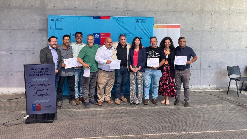 Personas asistentes a la ceremonia de cierre del PER, todos posando a la cámara y algunas personas con diplomas.