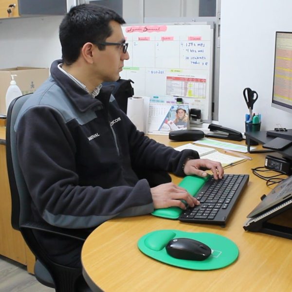 Programa de Inclusión laboral Hombre sentado en su escritorio, concentrado frente a la computadora, trabajando con atención. Entorno de oficina.